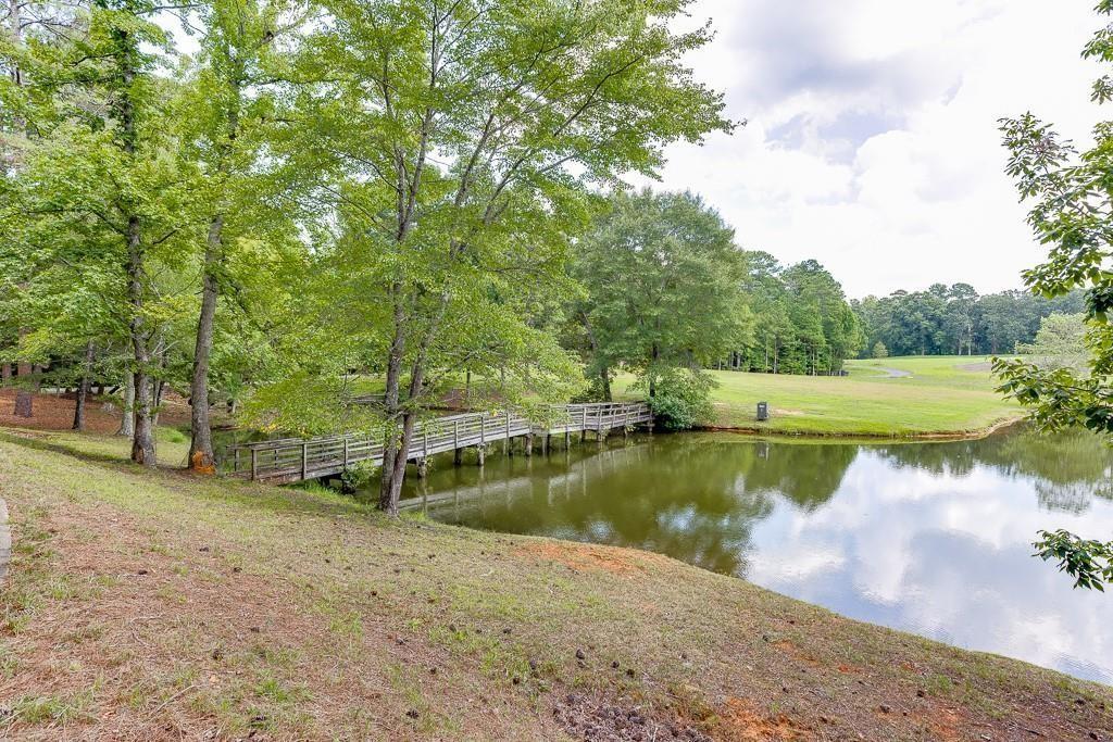 5775 Kennedy Road Suwanee, GA 30024 - Photo 7 of 23 a view of a lake with a yard and large trees