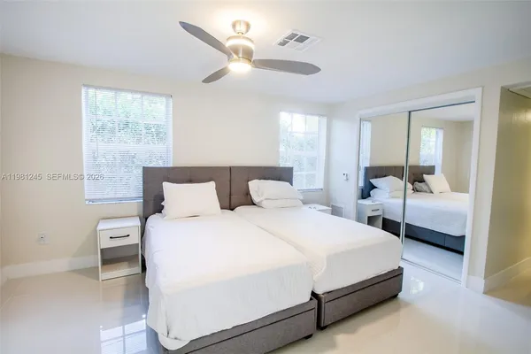 a spacious bedroom with a bed and a large mirror