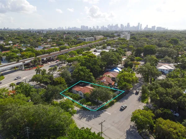 an aerial view of residential houses with outdoor space and trees