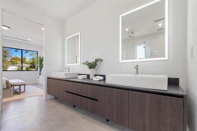 a bathroom with a double vanity sink and a large mirror