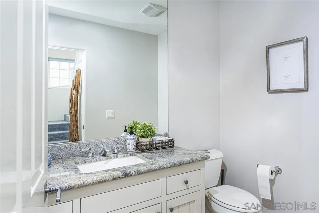 930 10th Street Coronado, CA 92118 - Photo 24 of 25 a bathroom with a granite countertop toilet sink and mirror