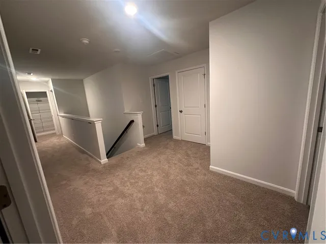 an empty room with staircase and white walls