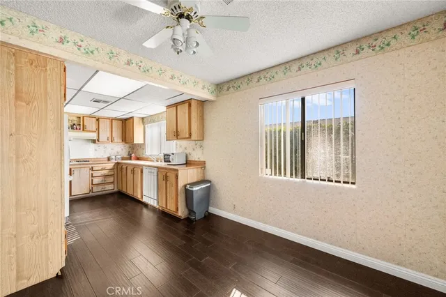 a kitchen with stainless steel appliances granite countertop a refrigerator a sink and wooden floors