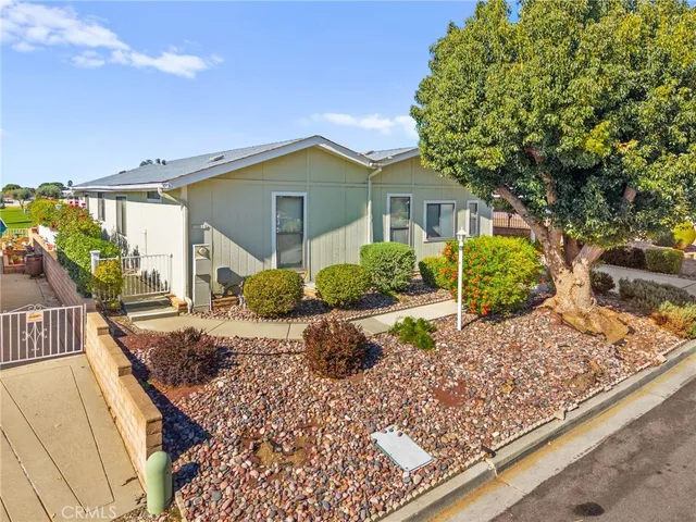 a front view of a house with a yard and potted plants