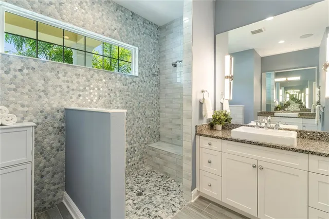 a kitchen with stainless steel appliances granite countertop a table chairs stove a sink dishwasher and cabinets with wooden floor