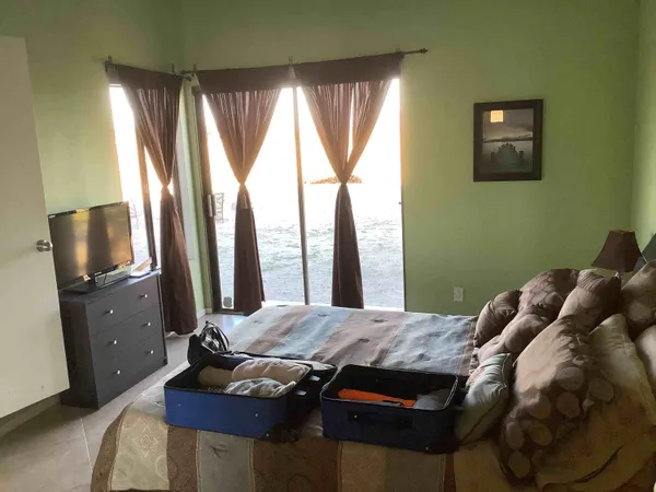 a bedroom with a bed and large windows