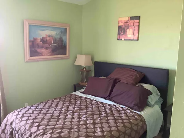 a bedroom with a bed and a painting on the wall