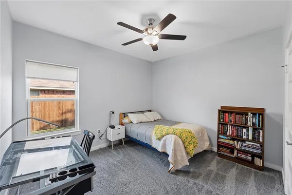 a bedroom with a bed and a ceiling fan