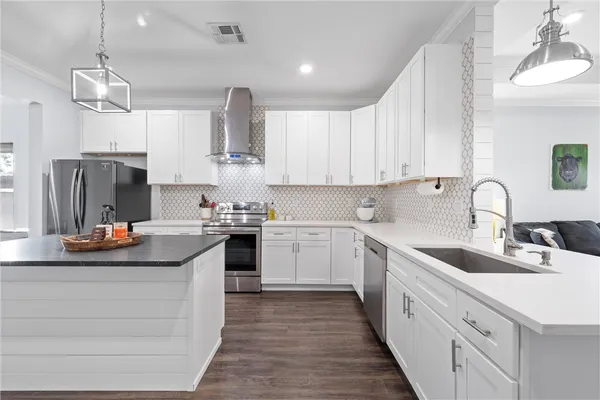 a kitchen with kitchen island granite countertop a sink stainless steel appliances and cabinets