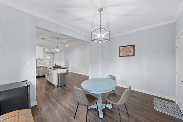 a view of a dining room with furniture a chandelier and wooden floor