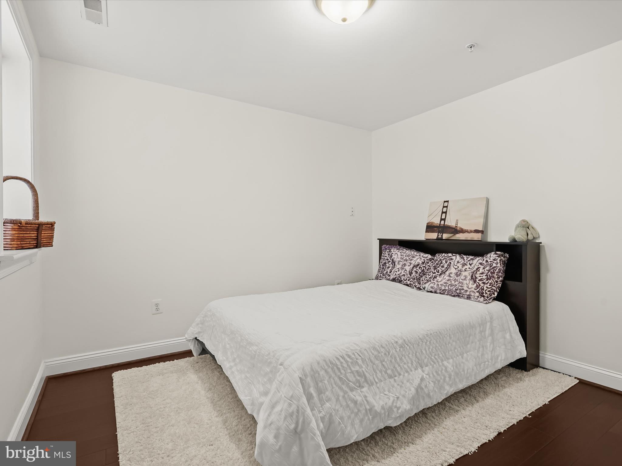 911 Kennedy Street Northwest, Unit 1 Washington, DC 20011 - Photo 8 of 18 a bedroom with a bed and a night stand