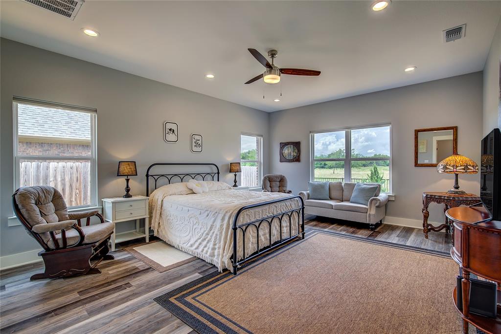 326 Koby Circle Sulphur Springs, TX 75482 - Photo 18 of 38 Primary bedroom has plenty of room for seating plus a king-size bed, can lighting, LVP floors and four windows for gorgeous natural light, with one-touch shades