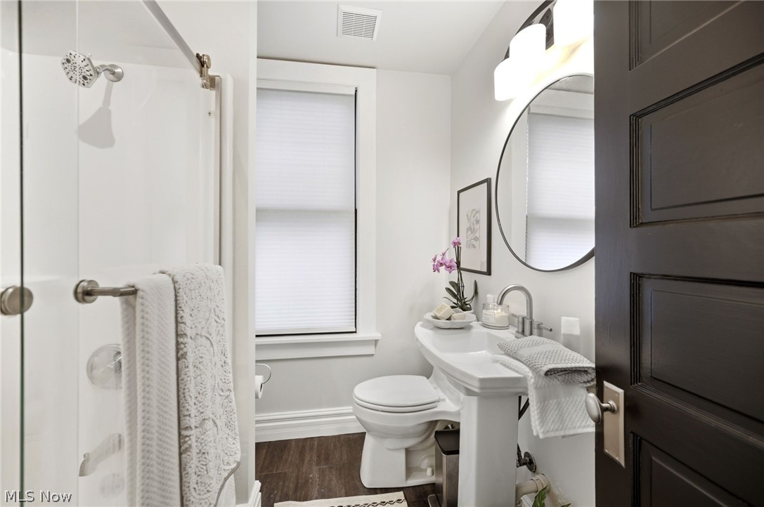4122 Middle Ridge Road Perry, OH 44081 - Photo 20 of 50 Compact bathroom featuring a white porcelain pedestal sink, round mirror, and a shower with a clear glass enclosure