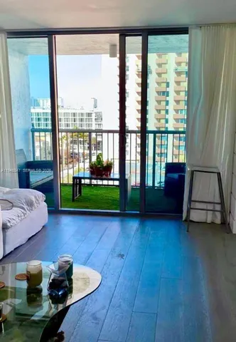 a living room with furniture and a floor to ceiling window