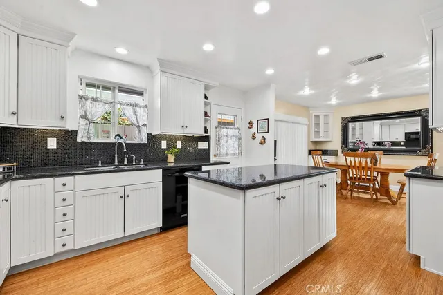 a kitchen with granite countertop a sink and cabinets