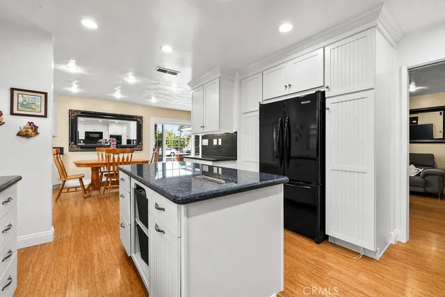 a kitchen with stainless steel appliances granite countertop a sink and a refrigerator