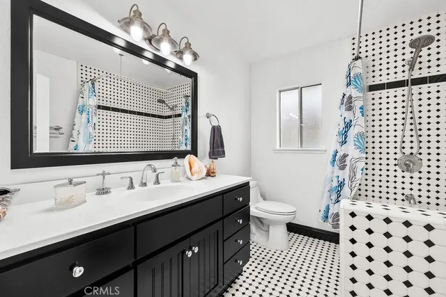 a bathroom with a double vanity sink toilet and a mirror