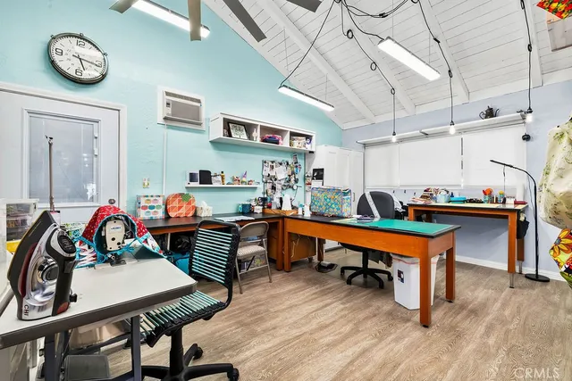 a room with stainless steel appliances kitchen island granite countertop furniture and a wooden floor