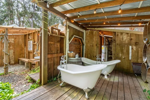 a view of a house with large trees and sitting area