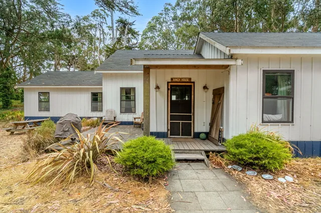a front view of a house with a yard covered with snow