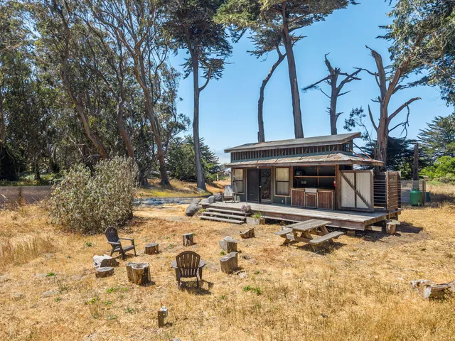 a view of a house with a yard and potted plants