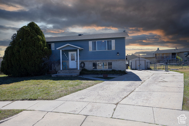 4644 South 3750th West Roy, UT 84067 - Photo 1 of 1 Raised ranch featuring brick siding, an outdoor structure, and a yard