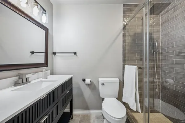 a bathroom with a toilet a sink and a mirror