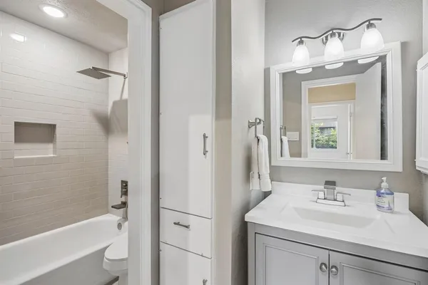 a bathroom with a sink a toilet and shower