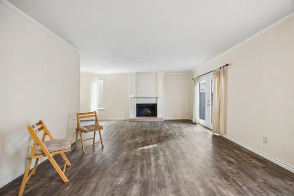a view of empty room with wooden floor and fireplace