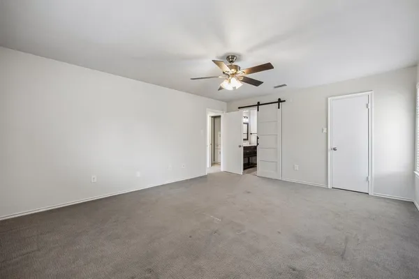 a view of an empty room with a ceiling fan