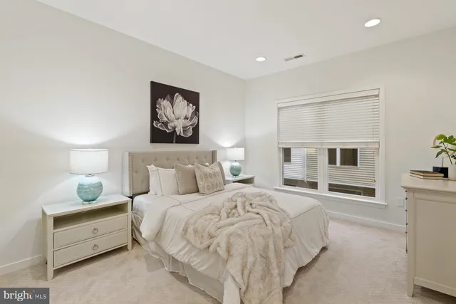 a spacious bedroom with a bed and a lamp