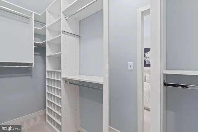 a view of walk in closet with empty racks