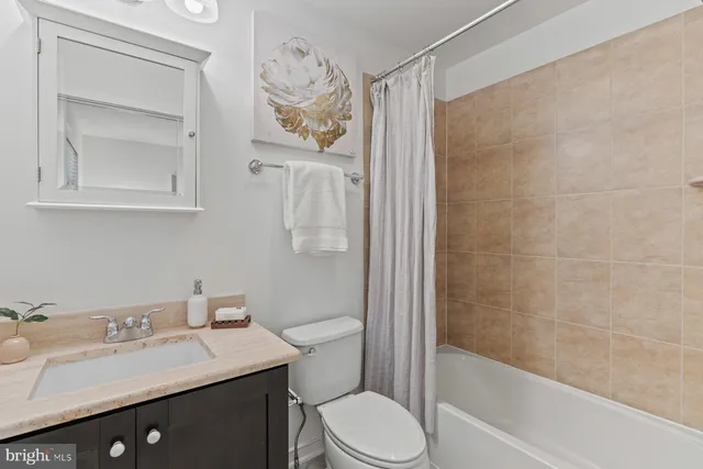 a bathroom with a sink vanity mirror and toilet