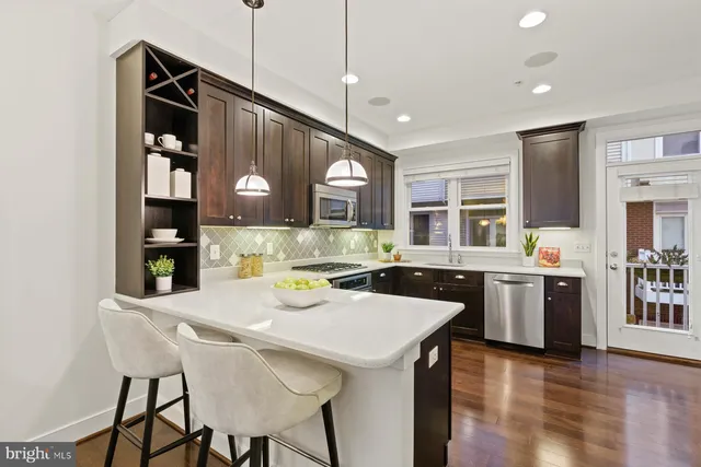 a kitchen with a dining table chairs stainless steel appliances and cabinets