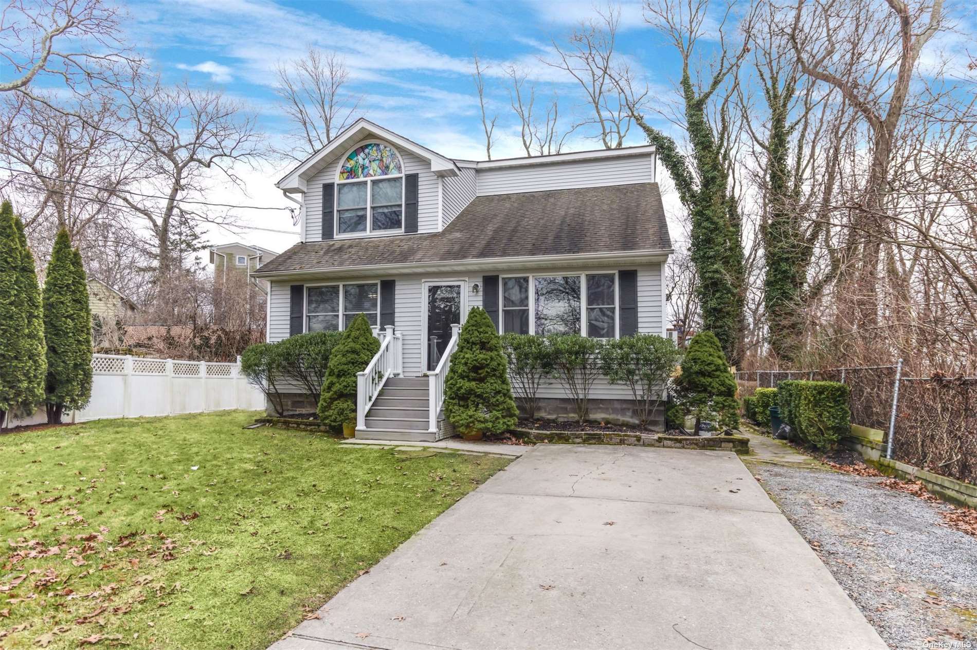 a front view of a house with a yard and potted plants