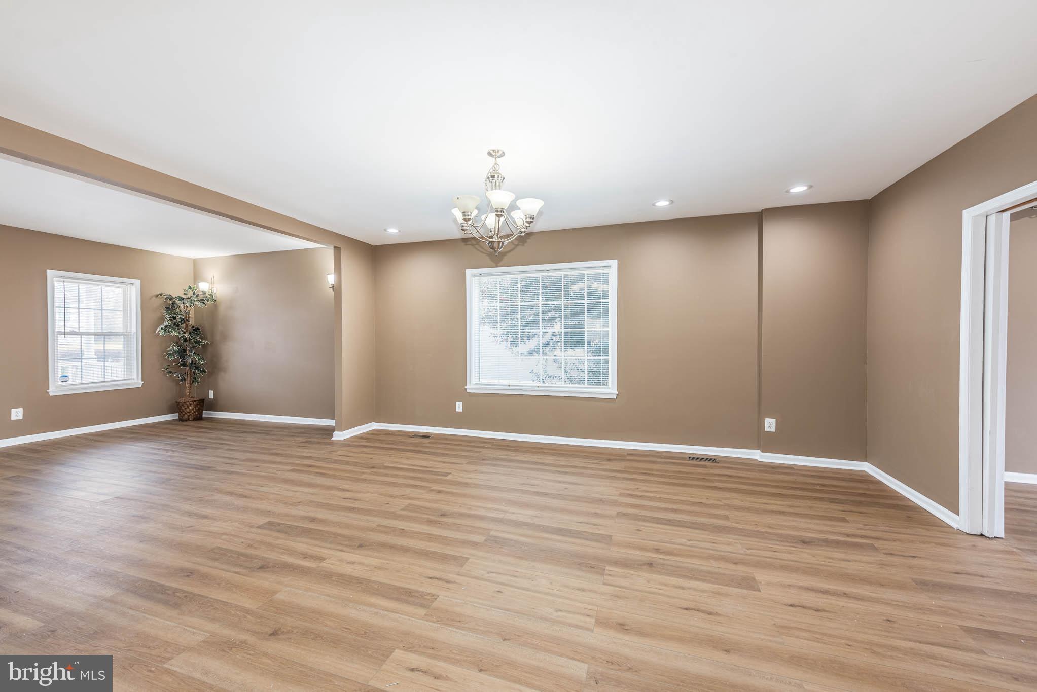 4021 Barrington Road Baltimore, MD 21207 - Photo 5 of 50 a view of an empty room with wooden floor and a window