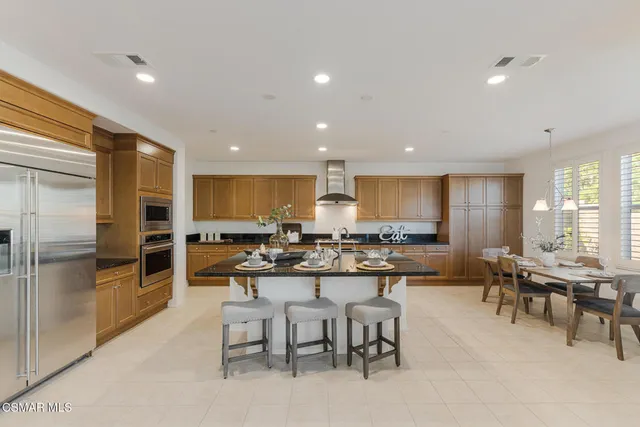 a kitchen with stainless steel appliances kitchen island granite countertop a stove and cabinets