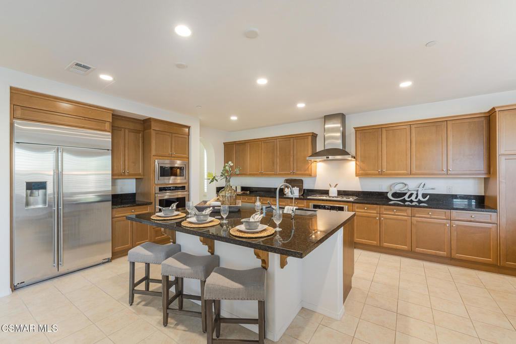 7020 Highgrove Place Moorpark, CA 93021 - Photo 18 of 59 a kitchen with stainless steel appliances granite countertop a stove top oven a sink a refrigerator and chairs