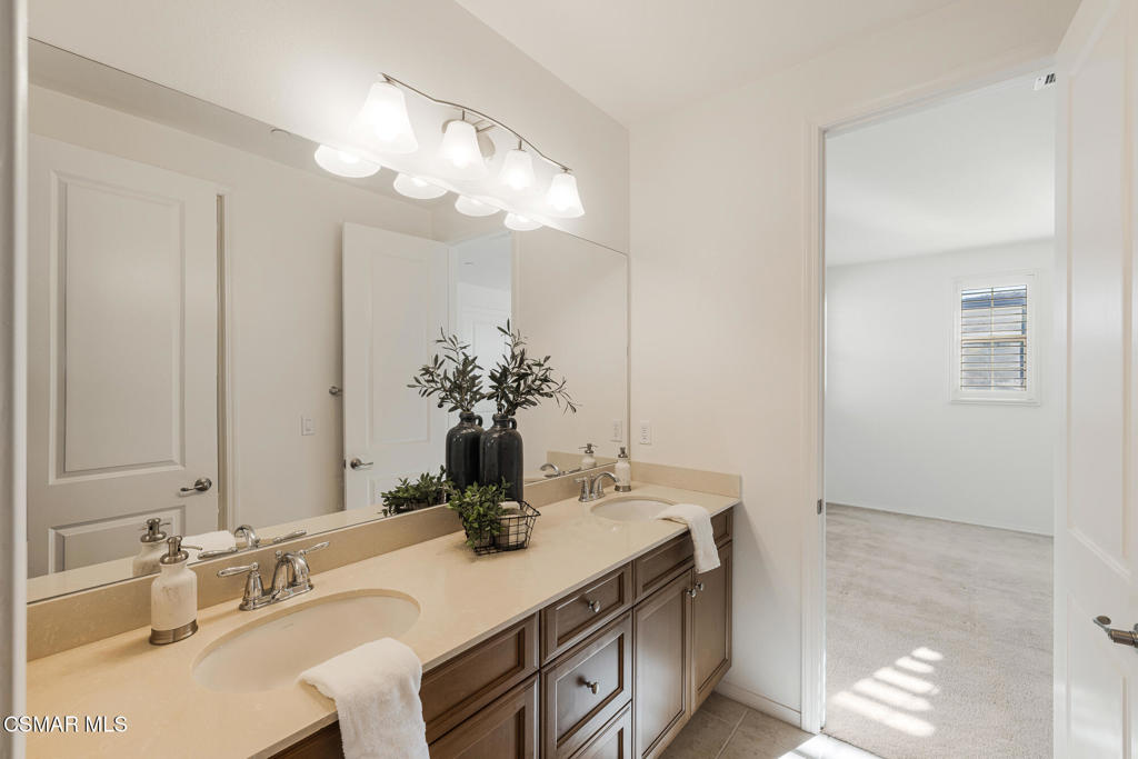 7020 Highgrove Place Moorpark, CA 93021 - Photo 34 of 59 a bathroom with a granite countertop sink a large mirror and a