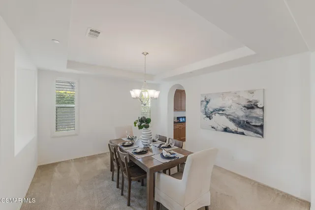 a view of a dining room with furniture and chandelier