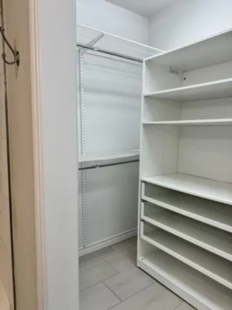 a view of walk in closet with empty racks