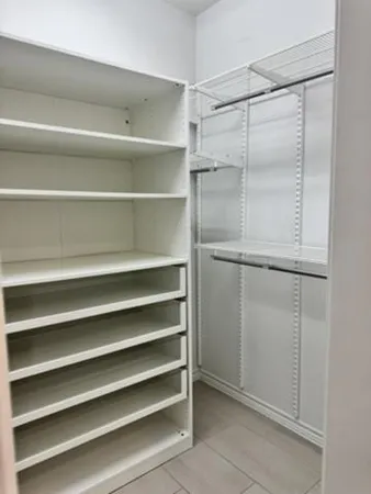 a view of walk in closet with empty racks