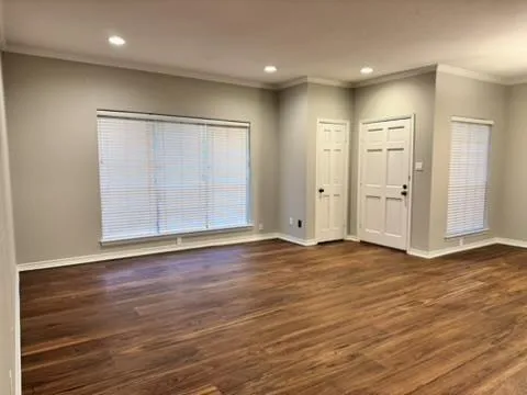 an empty room with wooden floor & closet area