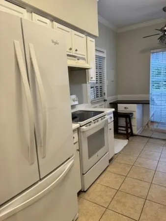 a kitchen with white cabinets and white appliances
