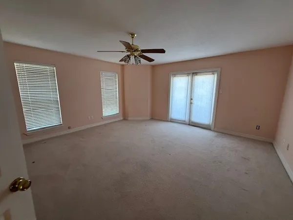 a view of a room with windows and ceiling fan