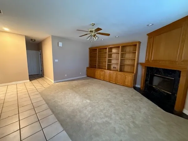 a view of an empty room with a fireplace and a window