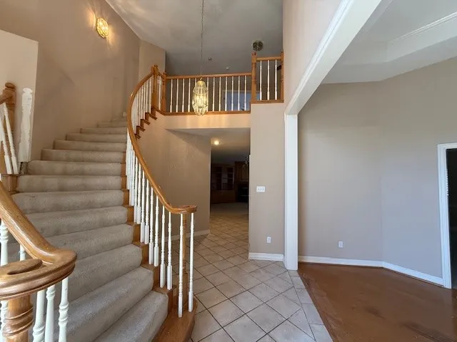 a view of staircase with railing and white walls