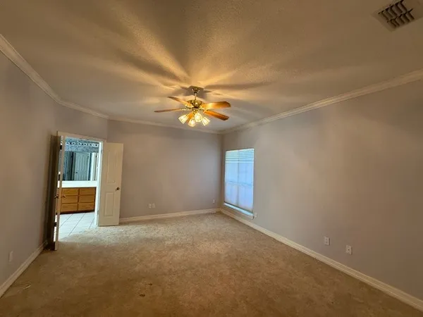 a view of an empty room with a chandelier fan