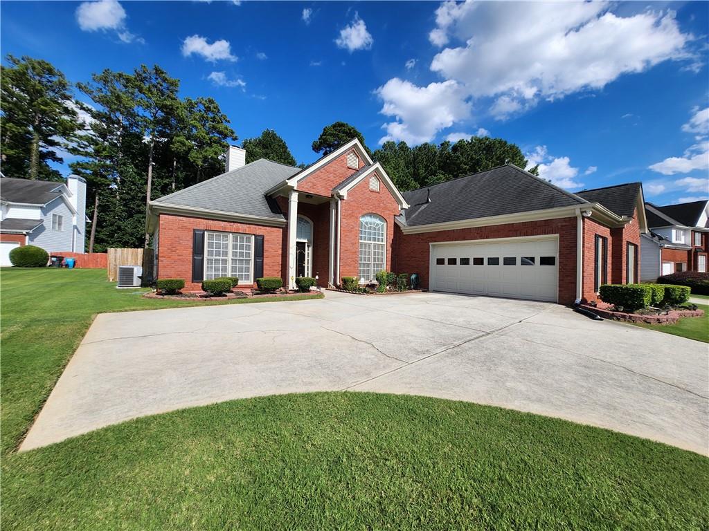 1021 Bay Pointe Way Southwest Lilburn, GA 30047 - Photo 1 of 1 a front view of a house with a yard and garage