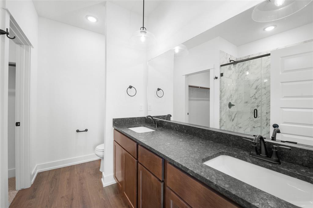 3000 Teasdale Road Lorena, TX 76655 - Photo 8 of 16 a bathroom with a granite countertop sink a toilet a large mirror and shower